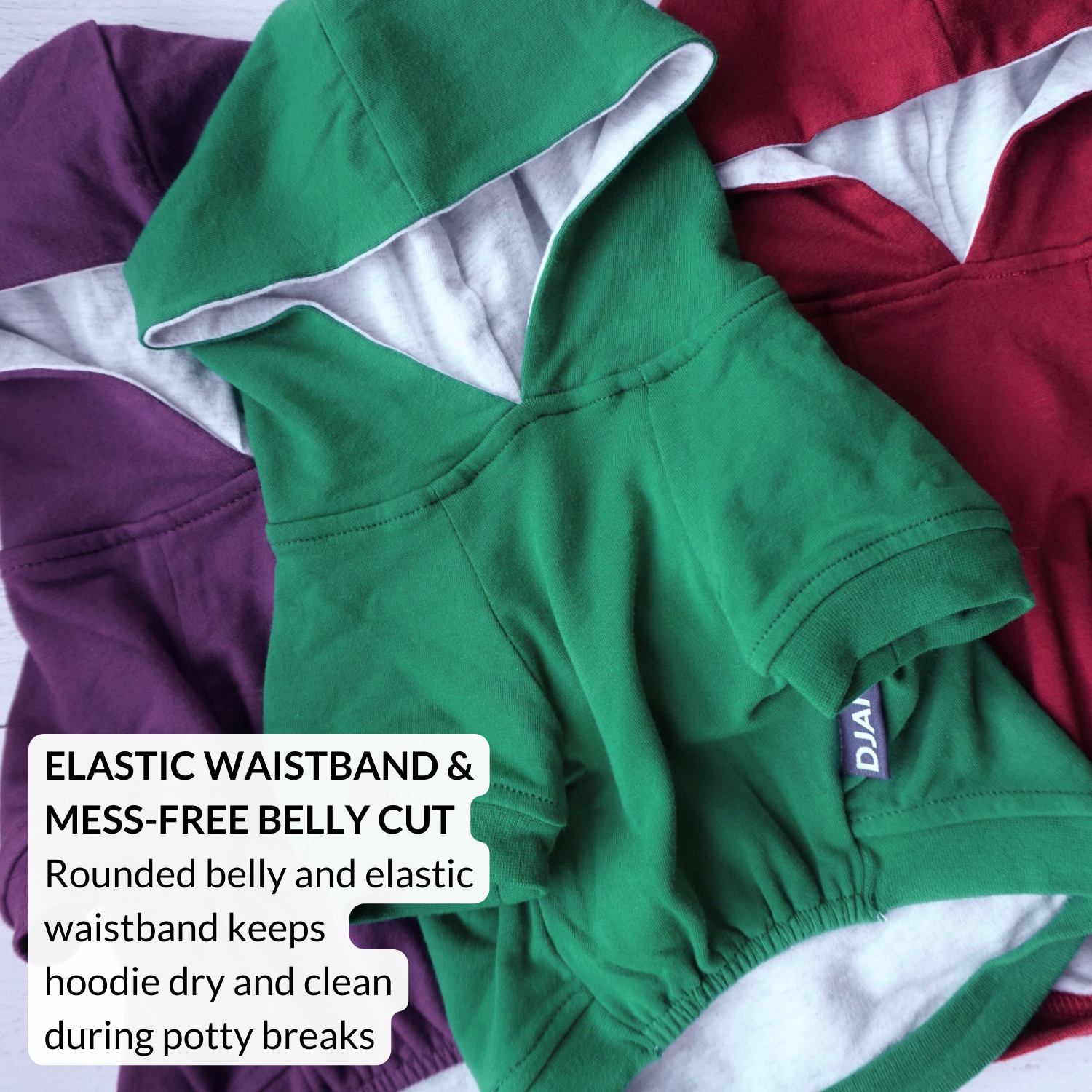 Green hoodie with text about elastic waistband and mess-free belly cut on a multicolored background