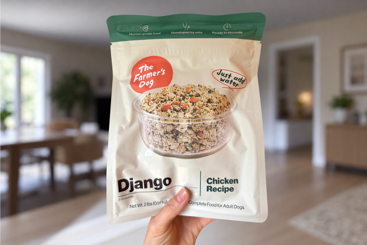 Dog mom's hand holding up a bag of The Farmer's Dog Instant Fresh dog food with modern kitchen backdrop