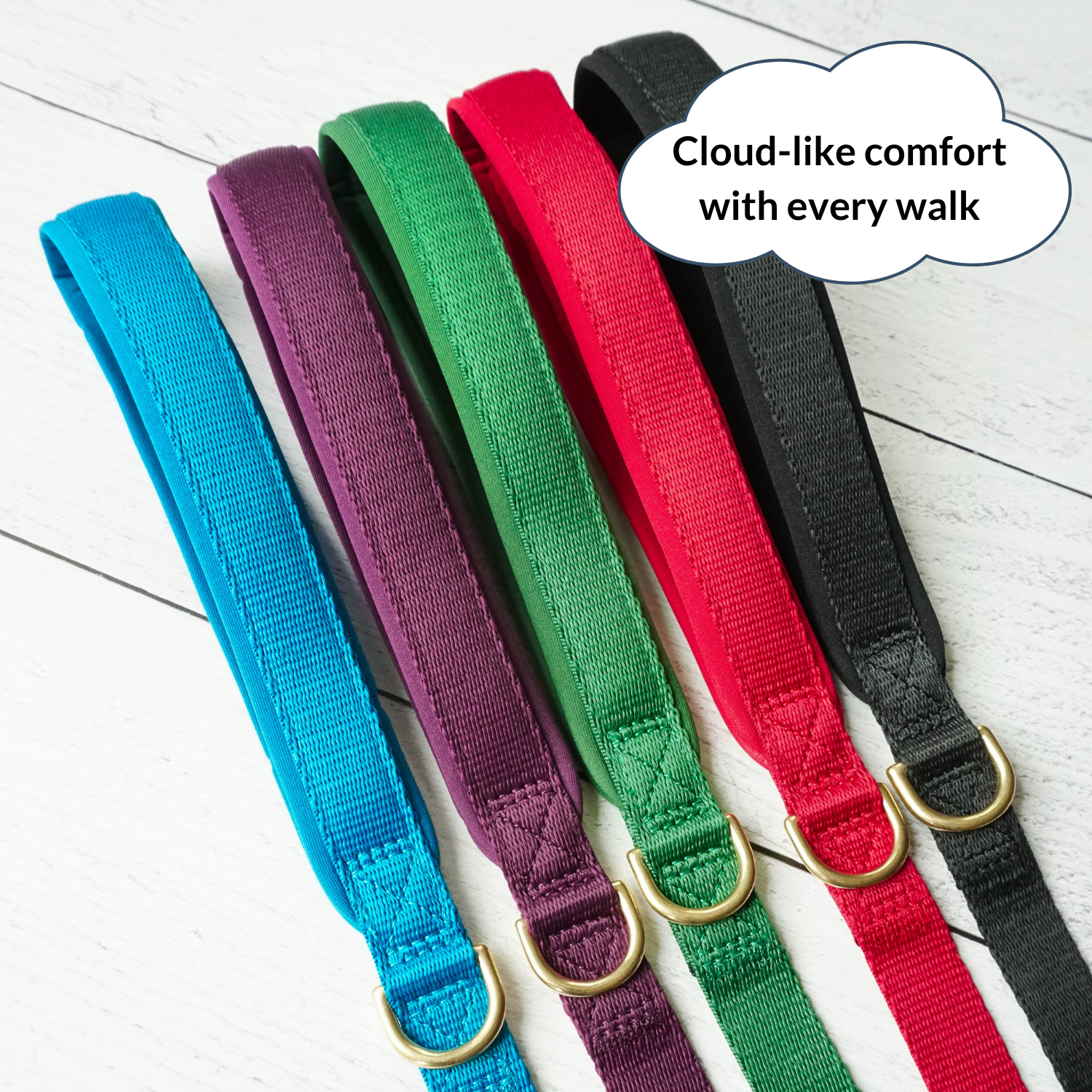 Set of colorful dog collars on a light wooden floor with a speech bubble indicating comfort.
