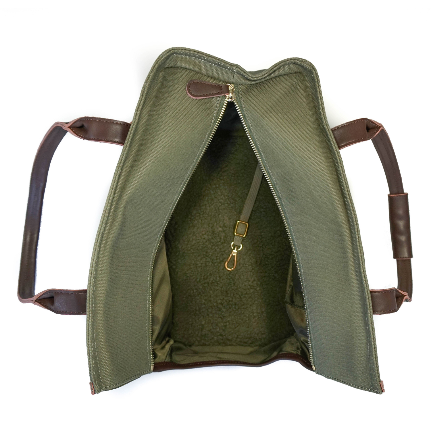 Interior of olive green waxed canvas dog carrier tote bag with brown leather handles shown on a white background
